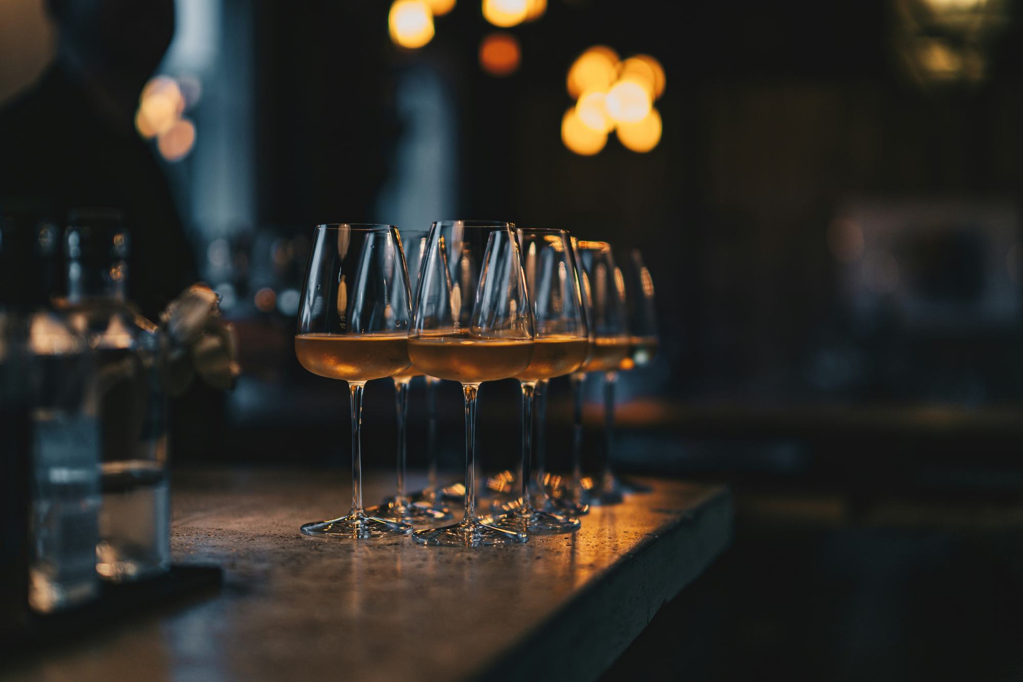 Glas med orangevin på række på baren om aftenen